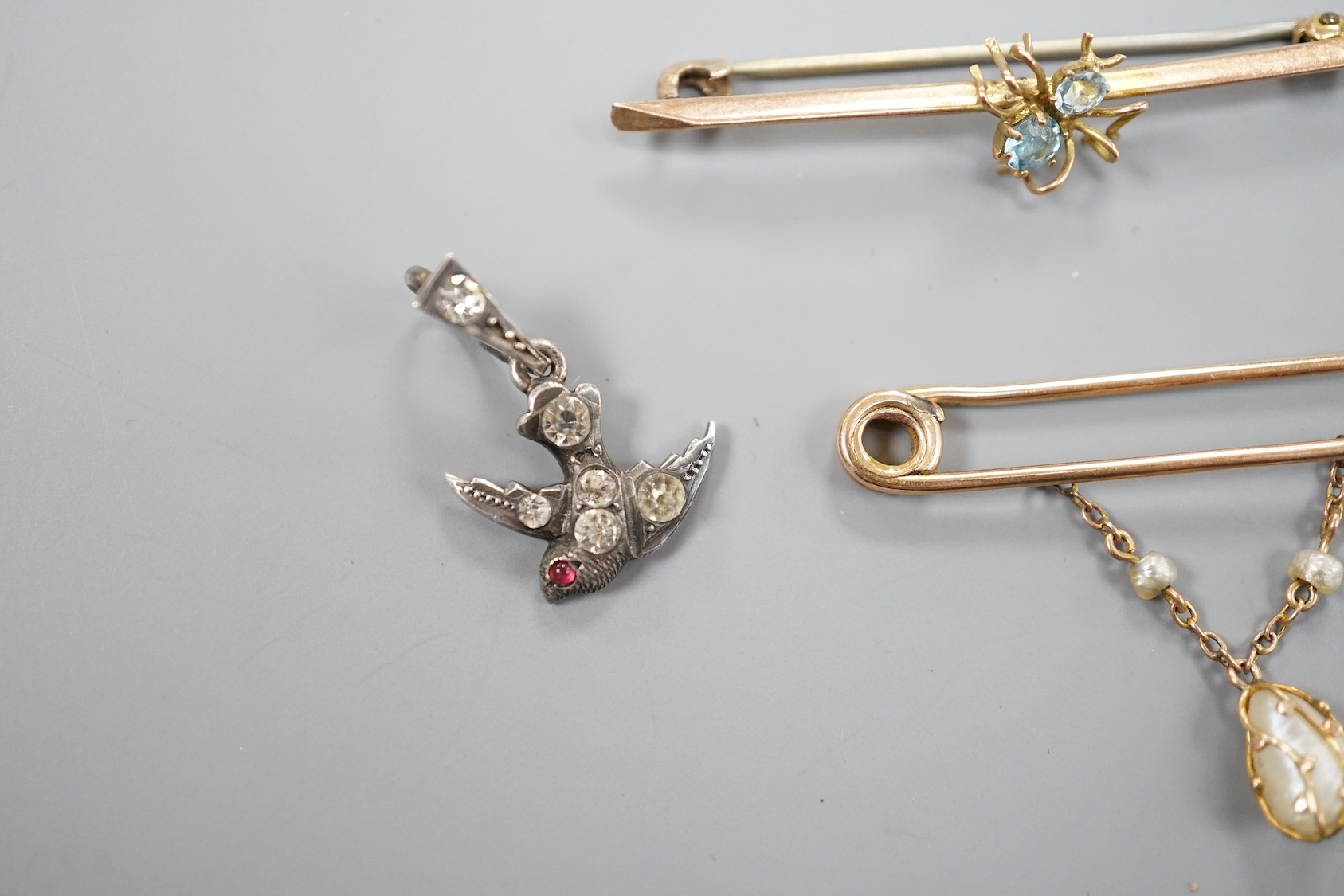 A modern 9ct gold and opal set bug brooch, 24mm, a paste set white metal swallow pendant and similar brooch and two yellow metal bar brooches, one with gem set spider, the other with baroque pearl drop.